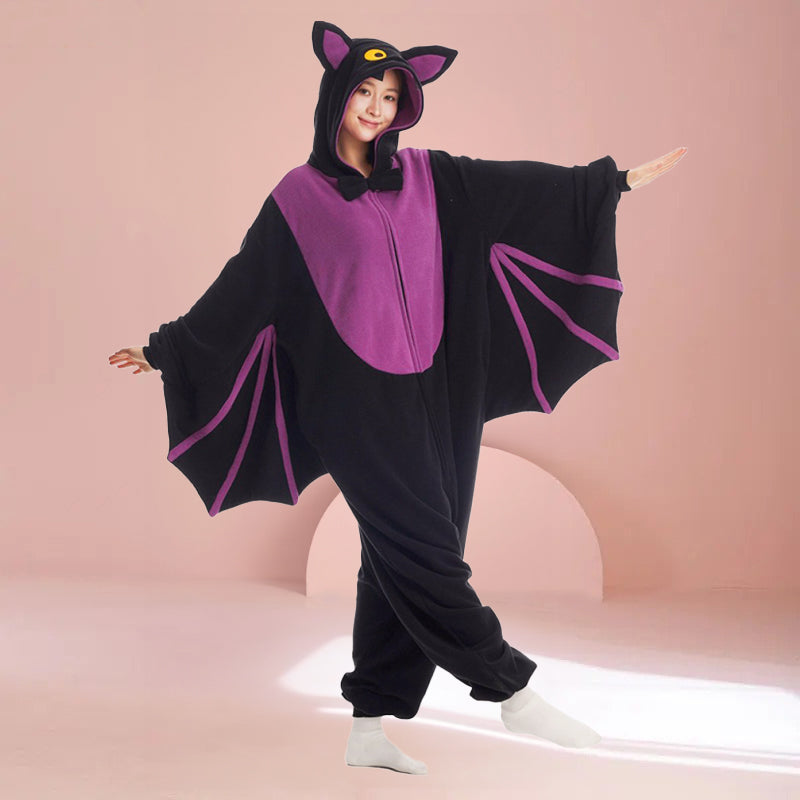 Adult bat onesie Halloween costume with purple chest and wings, for cozy and spooky October vibes, shown on pink background 