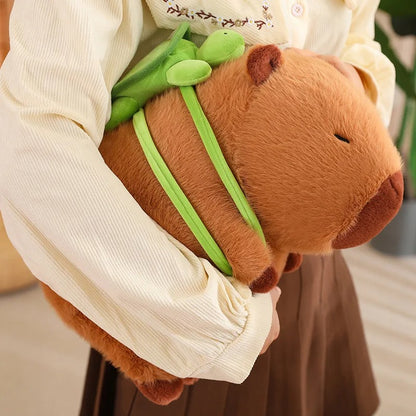Capybara plushie being hugged by girl, showcasing the soft texture and green turtle backpack – cozy stuffed animal ideal for cuddles and gifts.