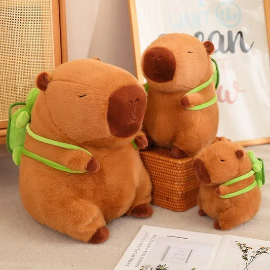 Display of three capybara plush toys in small, medium, and large sizes with turtle backpacks – adorable plush family perfect for gifting or collection.