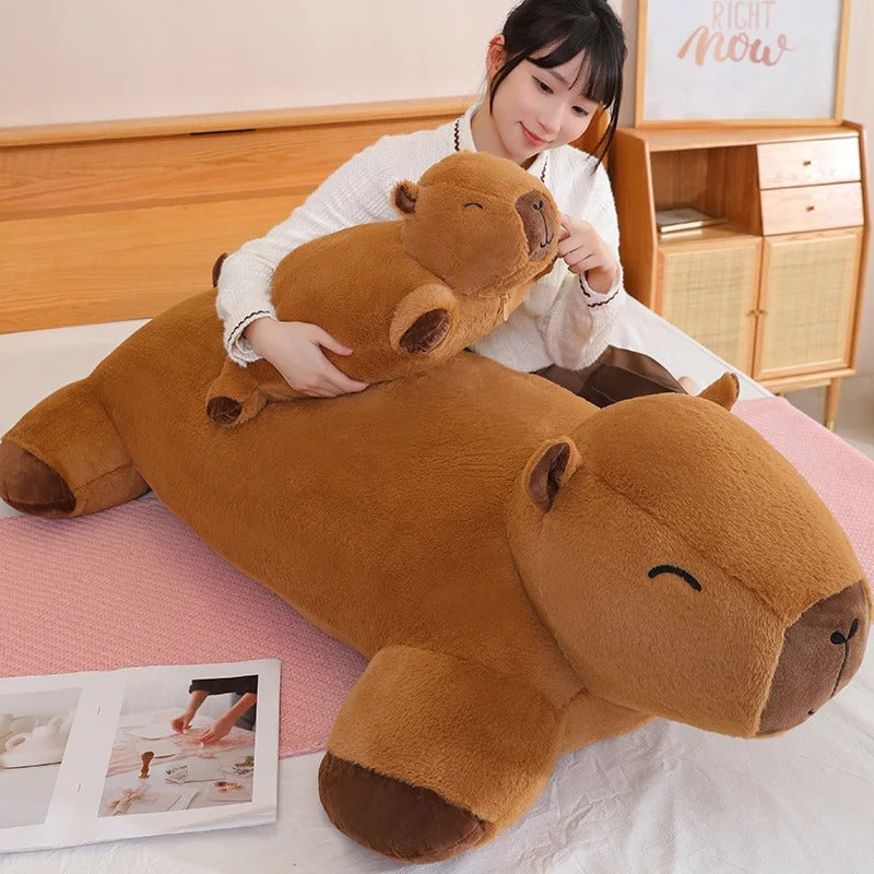 Woman hugging a giant capybara plush Jolly Dreams stuffed animal pillow, soft brown cuddle toy.