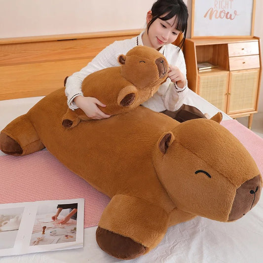 Woman hugging a giant capybara plush Jolly Dreams stuffed animal pillow, soft brown cuddle toy.