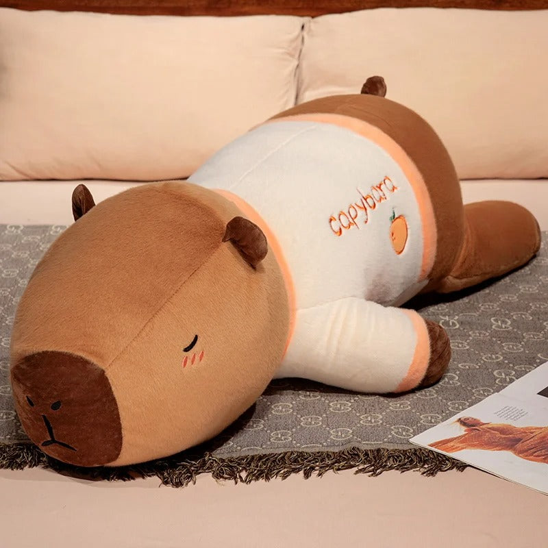 Giant capybara plush pajama party edition in orange fruit pajamas, cute cuddle pillow stuffed toy.