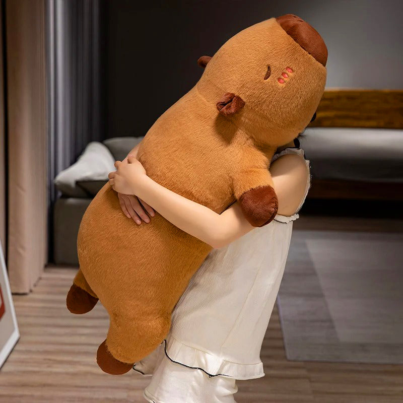 Girl hugging giant capybara stuffed animal upright, showing realistic size and cozy teddy bear quality.
