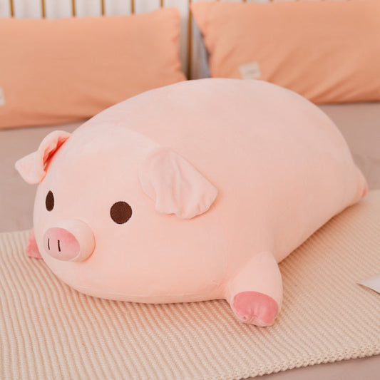 A large, soft pink kawaii squishy piggy plush lying on a bed, perfect for use as a cuddle toy or decorative pillow.